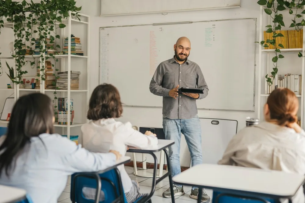 A teacher presenting in front of a whiteboard