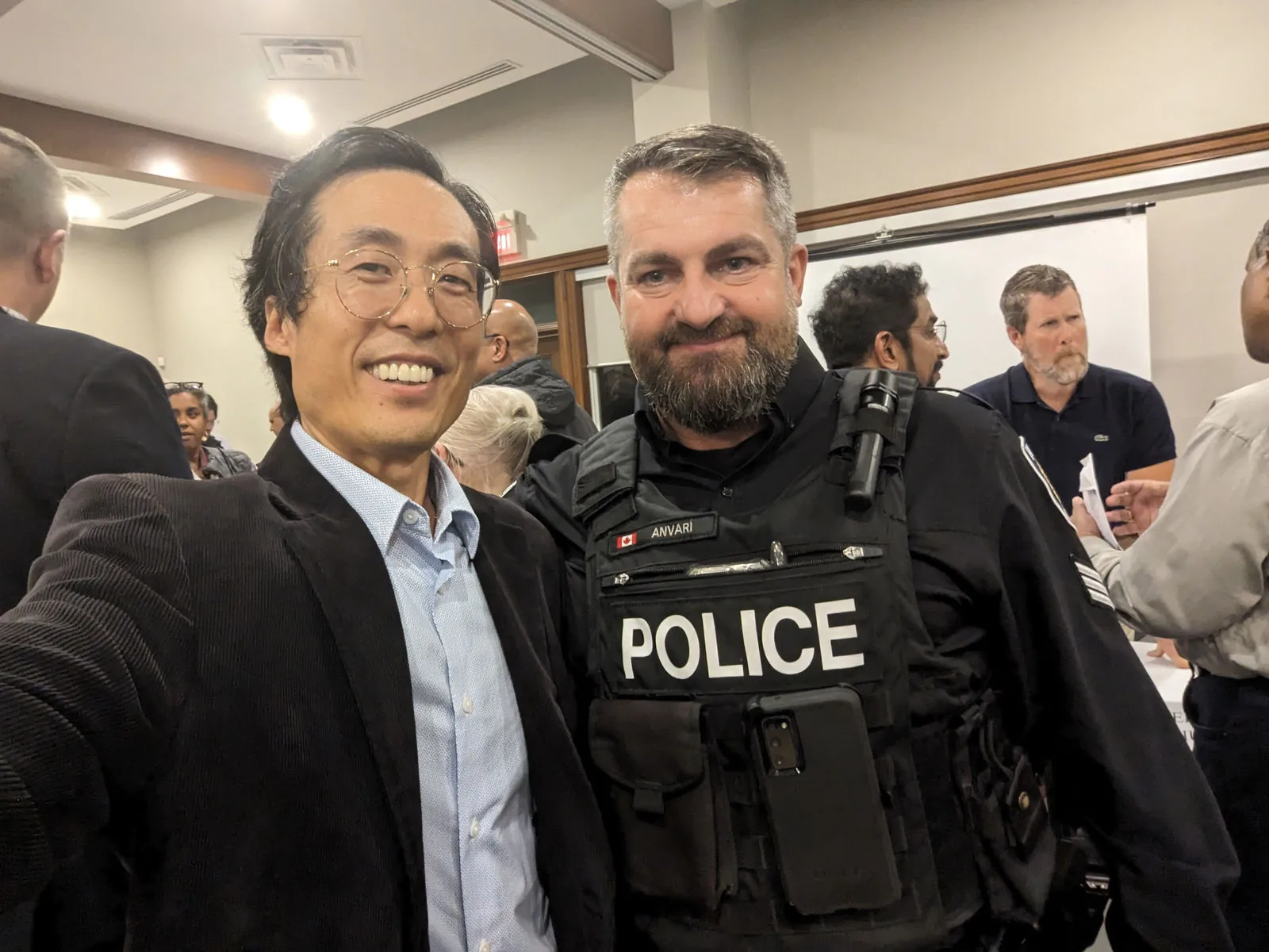 Kenneth Xi talking with a police officer at a community event.